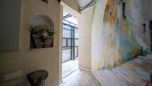 A corridor with a decorative gnome, a welcome sign, and a wall with a colorful mural.