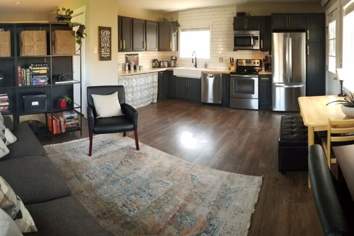 A modern kitchen with dark cabinetry, stainless steel appliances, and a central island.