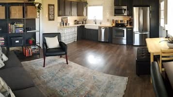 A modern kitchen with dark cabinetry, stainless steel appliances, and a central island.