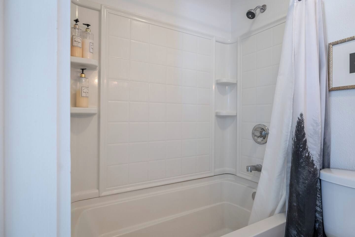 Een badkamer met een bad, een douche en een plank met toiletartikelen.