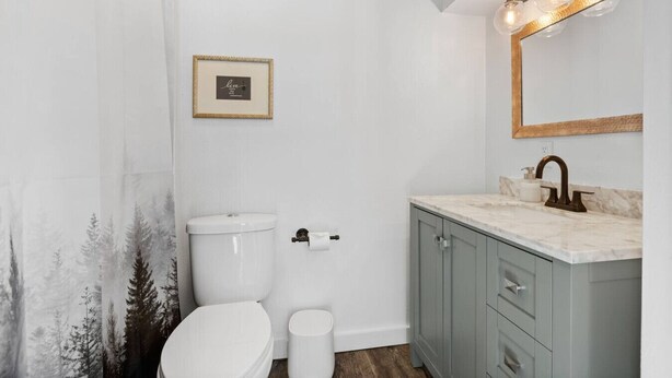 Une salle de bain avec des toilettes, un lavabo et un miroir.
