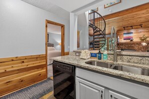 A modern kitchen with granite countertops, a dishwasher, and a built-in stove. - Creekside Unit 403 Spacious 3 bedroom river views, private deck, picnic area (Winter Park)