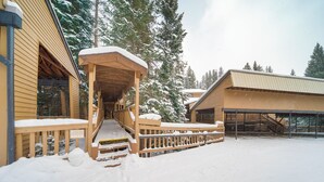 A wooden building with a covered porch and a staircase leading to a deck.