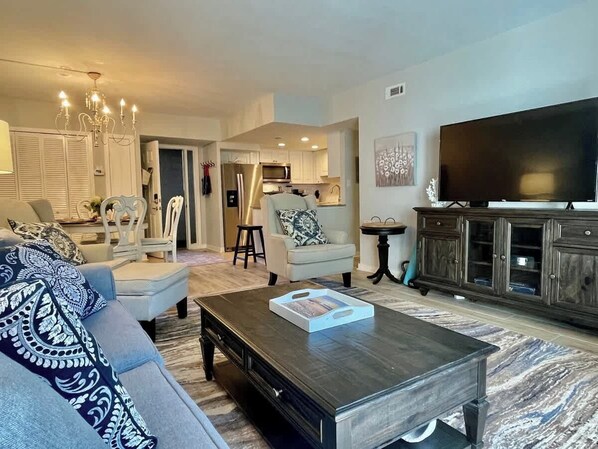 A living room with a sofa, armchair, coffee table, TV, and a cabinet. - Luxury Villa w/ Patio Steps from Beach Hilton Head (Hilton Head Island)
