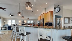 A spacious kitchen with a central island, bar stools, pendant lighting, and modern appliances. - Eagles' Landing | Private Pool + Hot Tub, Views! (Surf City)