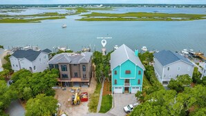 A residential area with houses near a body of water, a kayak launch point, and a dock with boats. - Eagles' Landing | Private Pool + Hot Tub, Views! (Surf City)