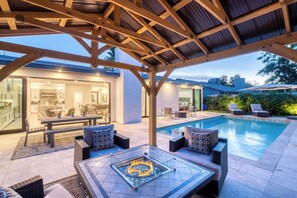 A covered outdoor area with a pool, seating, and a fire feature. - Scottsdale Getaway | Chic Comfort, Pool & Gather Spaces (Scottsdale)