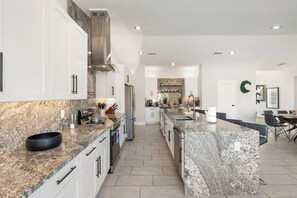 A modern kitchen with granite countertops, stainless steel appliances, and a central island.
