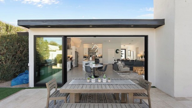 Una casa moderna con un patio, comedor y un espacio de sala de estar integrado.