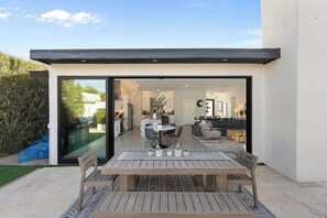 A modern house with a patio, a dining area, and an open-plan living space. - Scottsdale Getaway | Chic Comfort, Pool & Gather Spaces (Scottsdale)