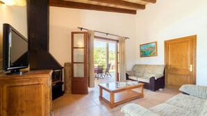 A cozy living room with a fireplace, a television, and a sofa. - CADELL PETIT. Charming house a short drive away from Pollensa (Pollensa / Pollença)