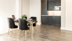 Una cocina moderna con armarios oscuros, un fregadero de acero inoxidable y un microondas.