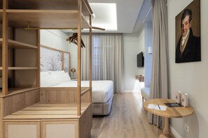 A modern hotel room with a wooden canopy bed, a small round table with a menu, and a painting on the wall. - Malabar by Petit Palace Anteriormente Icon Malabar (Málaga)
