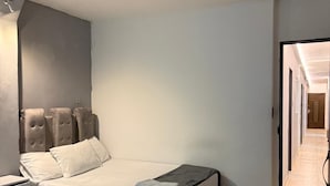 A modern hotel room with a large bed, two smaller beds, a desk, and a walk-in closet. - house with jacuzzi near lleras park  (Medellin)