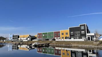 A row of colorful buildings along a calm water body, reflecting the structures.