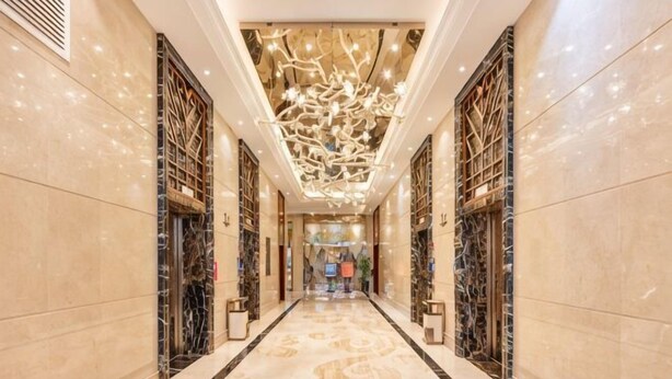 A luxurious hotel corridor with marble floors, ornate ceiling design, and symmetrical wall decorations. - Taihe Hotel (Guyuan)
