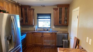 A kitchen with wooden cabinets, stainless steel appliances, and a granite countertop. - Watch Florida sunsets from the covered lakefront dock (Minneola)
