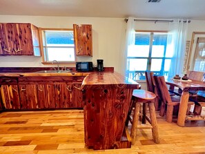 A rustic kitchen with wooden cabinets and a central island.