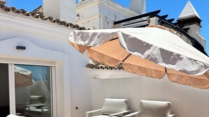 A patio with white outdoor furniture, including a sofa and two chairs, under a large umbrella. - Exclusive Duplex Penthouse with panoramic views  (Marbella)