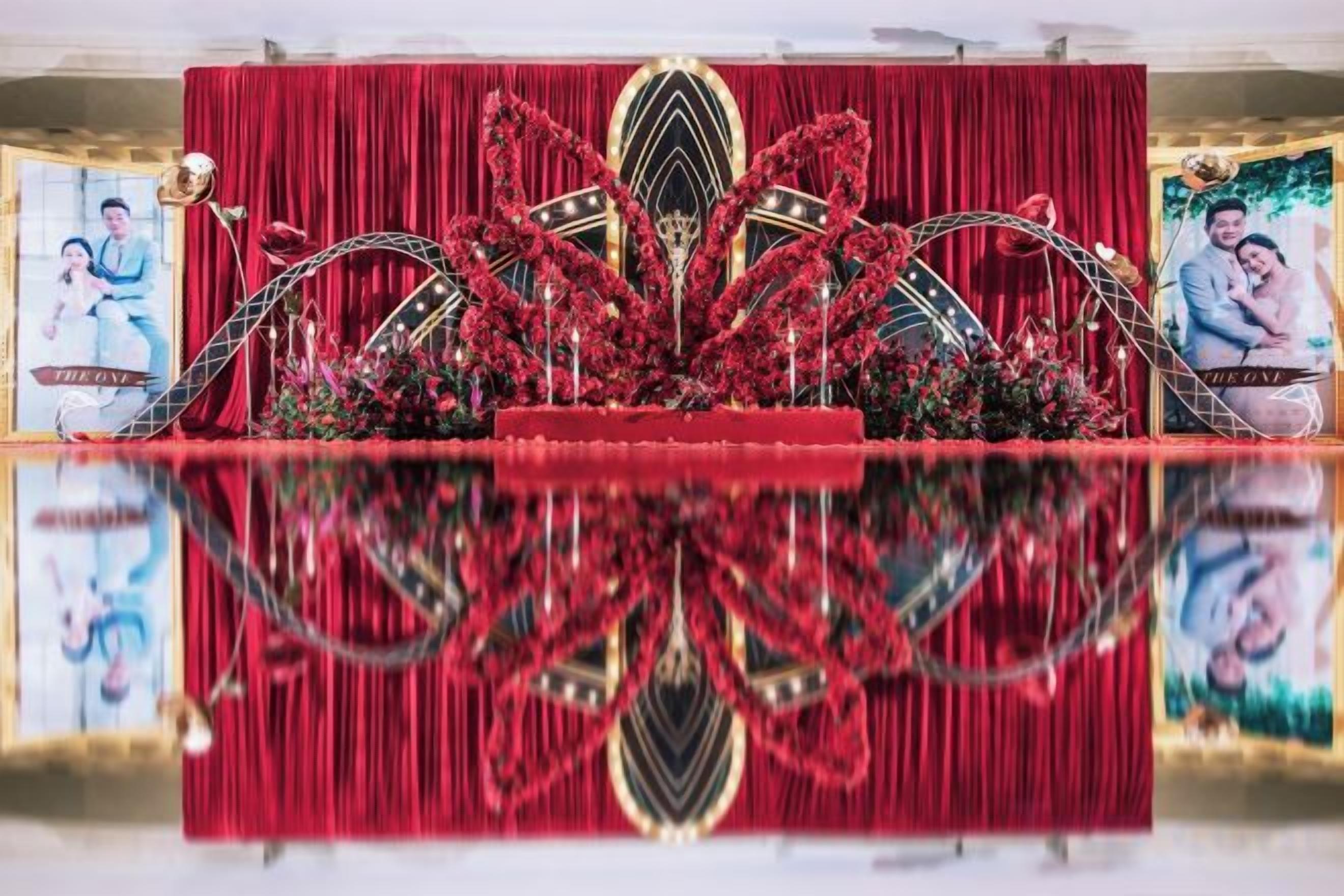 A stage with a red backdrop and reflective flooring, likely for an event or performance.