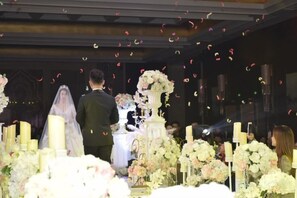 A wedding ceremony with a couple standing at the altar, surrounded by floral arrangements and candles. - Binhu Hotel (Hanchuan)