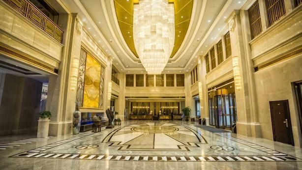 A grand lobby with a large chandelier, marble flooring, and a symmetrical layout. - Binhu Hotel (Hanchuan)