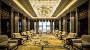 A conference room with a large carpet, chairs, and a chandelier. - Binhu Hotel (Hanchuan)