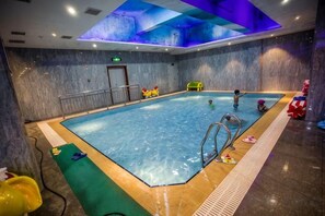 An indoor swimming pool with a clear water surface, a diving board, and a tiled floor. - Binhu Hotel (Hanchuan)
