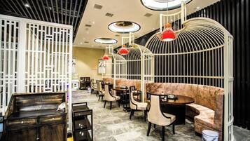 A modern interior with round tables, cushioned seating, and unique red pendant lighting.