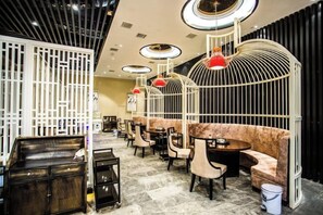 A modern interior with round tables, cushioned seating, and unique red pendant lighting. - Binhu Hotel (Hanchuan)