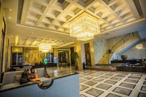 A hotel lobby with a chandelier, seating area, and a staircase. - Binhu Hotel (Hanchuan)