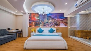 Ein modernes Hotelzimmer mit einem großen Bett, einem Schreibtisch und einer Sitzecke.