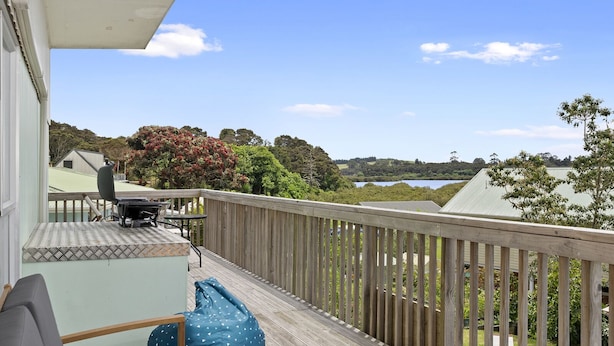 A wooden deck with a view of a lake and hills.