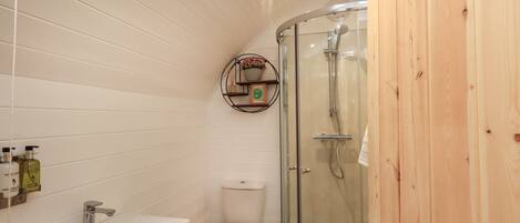 Een badkamer met een wit wastafel, toilet en douche met glazen wanden.