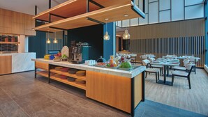 A modern restaurant with a central island, wooden ceiling, and contemporary lighting. - Fairfield by Marriott Chow Kit Kuala Lumpur (Kuala Lumpur)