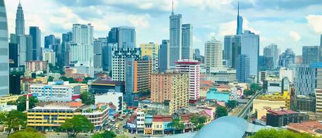 A cityscape with a mix of high-rise buildings and mid-rise structures, including a prominent hotel with a red and white facade.