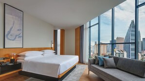 A modern hotel room with a large bed, a sofa, and a city view through large windows. - Fairfield by Marriott Chow Kit Kuala Lumpur (Kuala Lumpur)