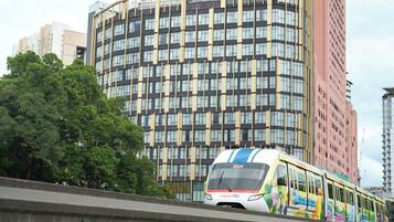 A train on an elevated track with a cityscape in the background.