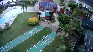 A residential area with a swimming pool, tennis courts, and solar panels on a building. - Banyan Harbor - Your home away from home! (Lihue)