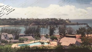 A residential area with a swimming pool, houses, and a view of the ocean. - Banyan Harbor - Your home away from home! (Lihue)