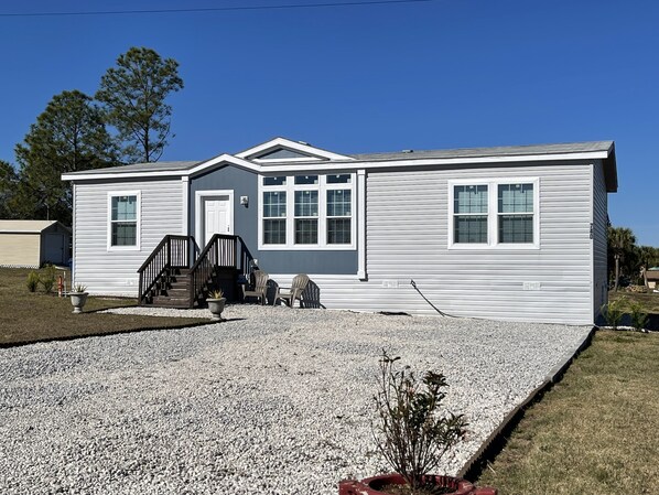 A single-story house with a front porch, a driveway, and a small front yard.