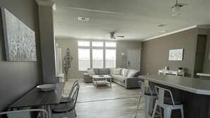 Une cuisine moderne avec un coin repas, un canapé et un ventilateur de plafond.