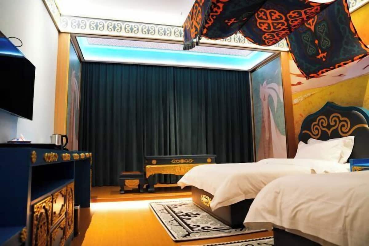 A hotel room with a bed, a desk, a chair, and a television.