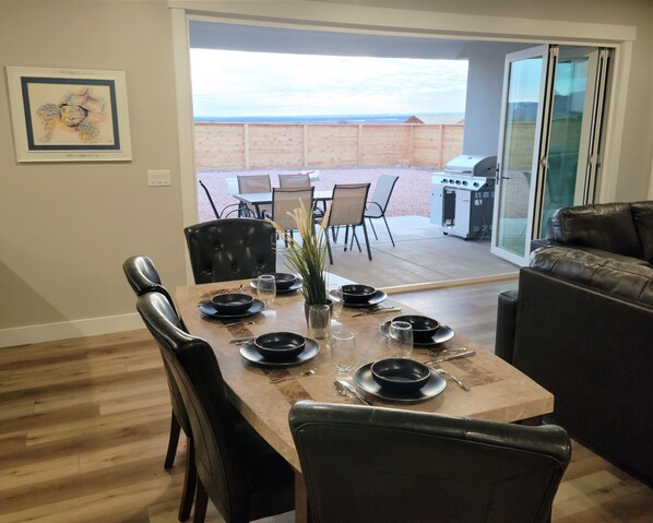 A dining area with a table set for four, chairs, a grill, and a view of the beach. - Kanab, Utah, Family, Outdoor Space, Zion's, Bryce, Grand Canyon, Best Friends (Kanab)