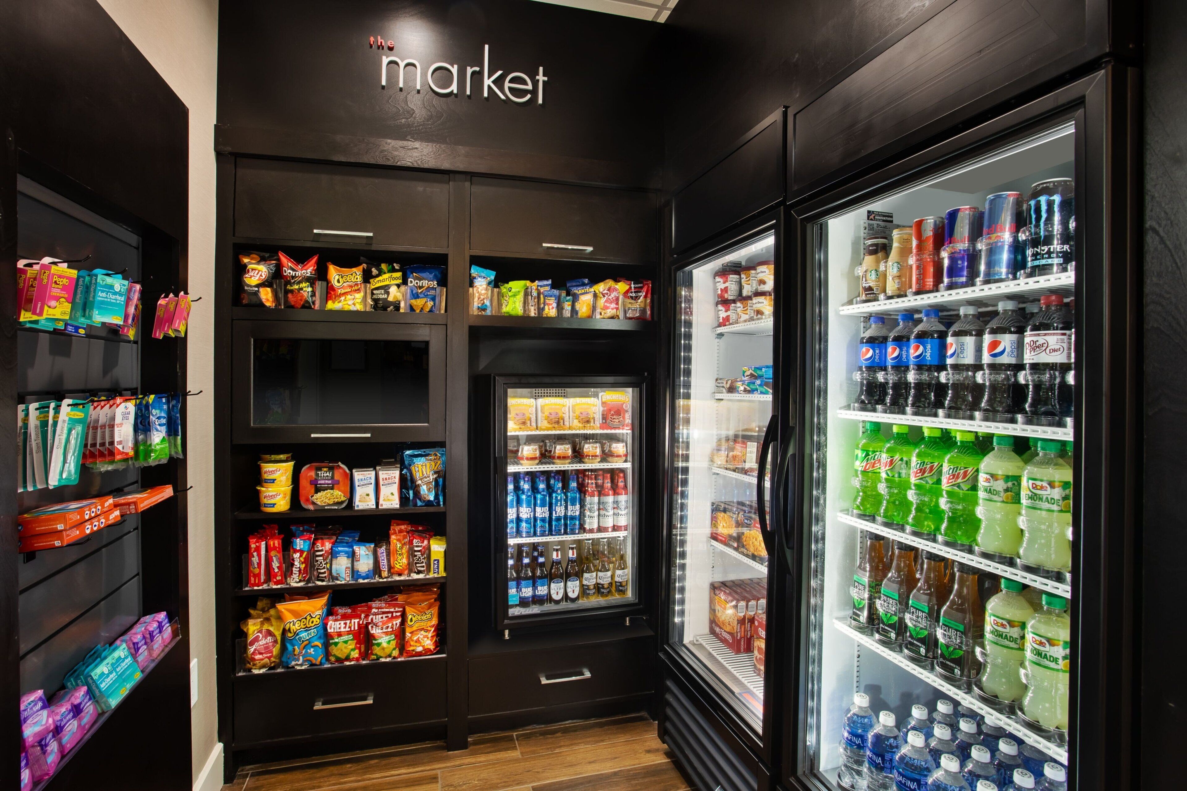 A well-stocked snack and beverage refrigerator in a hotel lobby.