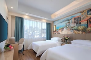 A hotel room with two beds, a desk with a laptop, a chair, and a painting on the wall. - Vienna Hotel (Kunming Baiyun Road Metro Station Jiang'an) (Kunming)