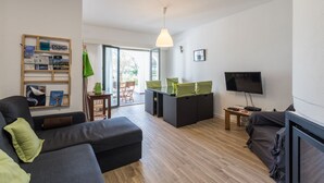 Una sala moderna con un sofá, un televisor y una estantería.