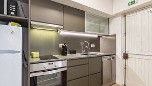 Una cocina moderna con electrodomésticos de acero inoxidable, horno integrado y un lavamanos.
