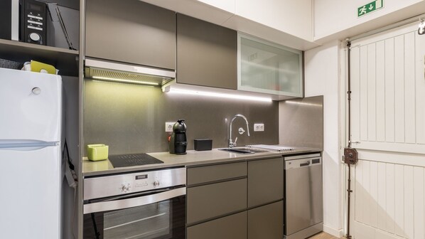 A modern kitchen with stainless steel appliances, a built-in oven, and a sink. - Green Oasis Villa c/ Estacionamento by LovelyStay (Quarteira)