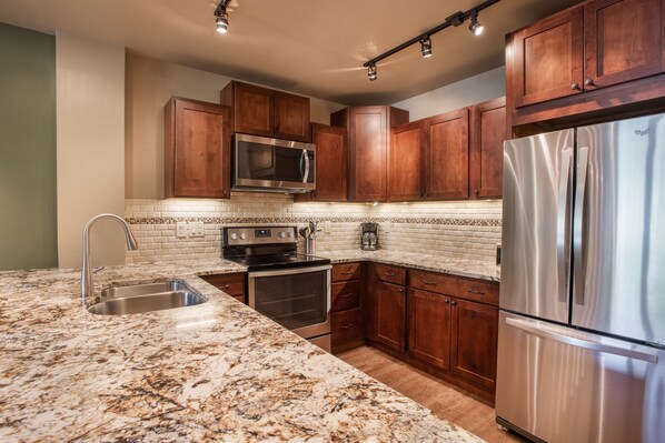 Enjoy cooking in this well-equipped kitchen with a refrigerator, microwave, double oven, and ample workspace.